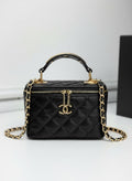 Chanel black quilted synthetic leather vanity crossbody bag with gold chain strap and CC logo.